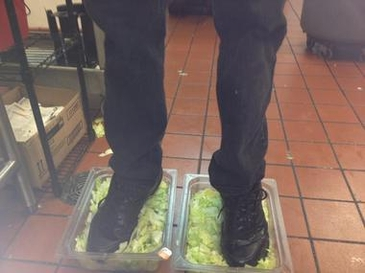 a burger king worker's feet in two beds of lettuce