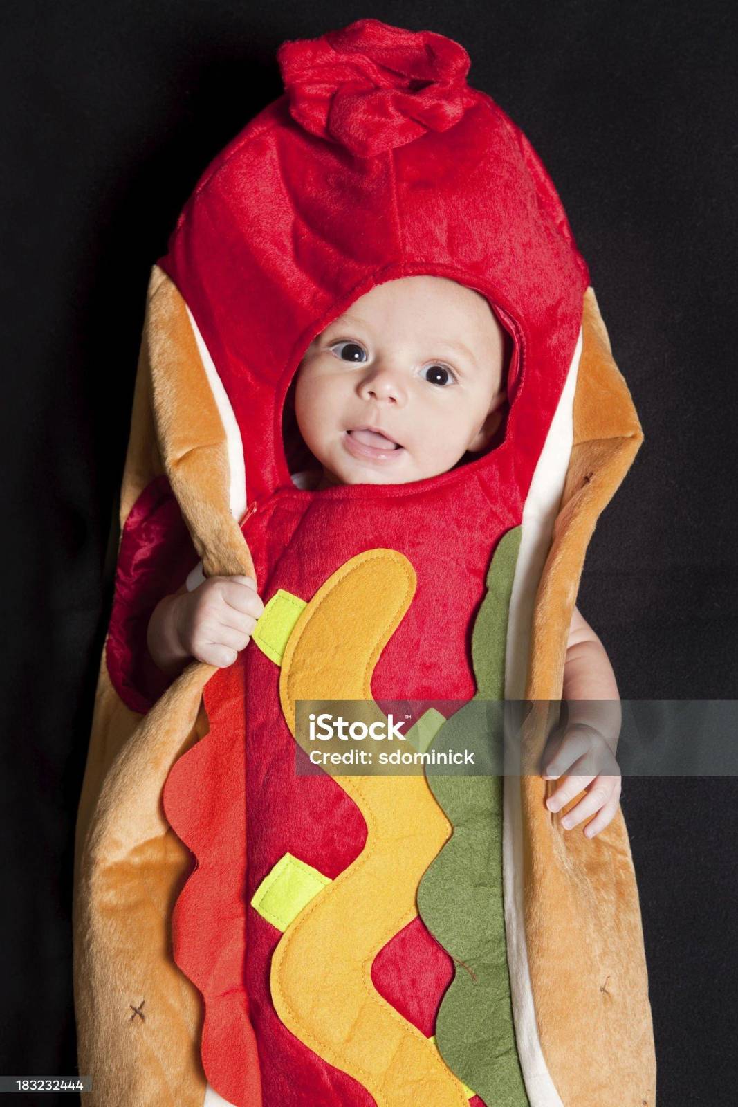 a poor quality screenshot of a baby in a hotdog costume